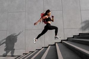 fit jong vrouw jumping en rennen foto