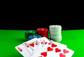 Koninklijk doorspoelen kaarten en poker chips in stapels Aan een groen tafel. foto