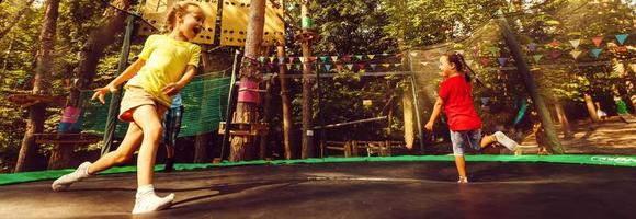 twee zoet kinderen, broers, jumping Aan een trampoline, zomer, hebben plezier. actief kinderen foto