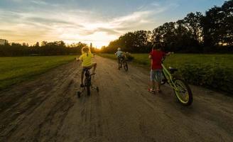 drie kind rijden een fiets. de kinderen in een helm rijden een fiets in de park. mooi kinderen. foto