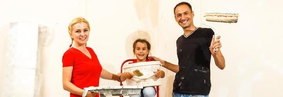jong familie aan het doen schilderij baan gedurende huis vernieuwing foto