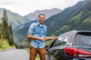 auto en bestuurder Mens in mooi berg landschap. portret van gelukkig Mens op zoek Bij visie en bergen gedurende zomer weg reis reizen foto