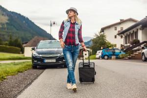 mooi toerist vrouw op reis in Europa en wandelen met koffer Aan stad straat. concept foto van mensen reizen.