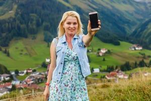 sportief vrouw nemen een fotograaf van een mooi panorama, nemen afbeelding met smartphone Alpen, Duitsland foto