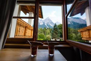 twee bril en twee broodjes voor ontbijt door de venster in de bergen foto