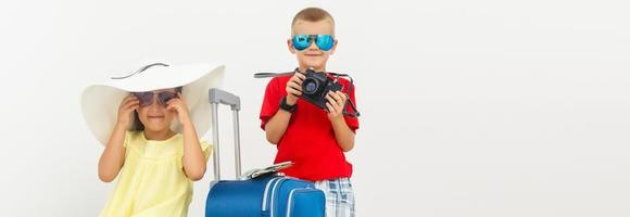 de jong reiziger kinderen met een koffer. geïsoleerd over- wit achtergrond foto