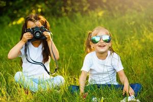 twee kinderen meisje vrouw, vrouw houden een camera nemen een afbeelding elk andere met glimlach foto