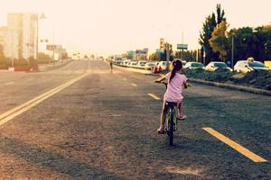 weinig meisje aan het leren rijden een fiets. voorjaar zomer herfst actief sport vrije tijd voor kinderen. kind Aan fiets foto