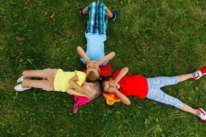 gelukkig kinderen aan het liegen Aan gras in park foto