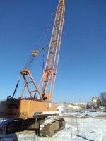 Sankt petersburg Rusland - 03 01 2023 mobiel bouw kranen met geel telescopisch armen en groot toren kranen in zonnig dag met wit wolken en diep blauw lucht Aan achtergrond, zwaar industrie foto