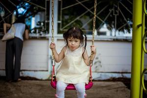 jong meisje swingend in een park foto