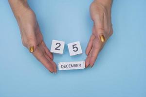 25 december houten kalender en handen foto