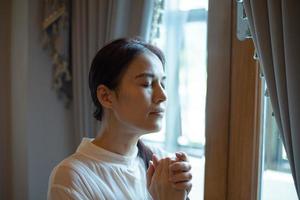 vrouw bidden bij een raam foto