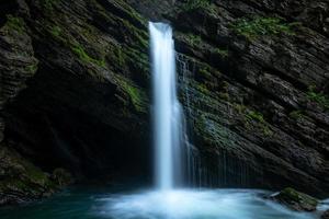 een mystiek waterval omringd door mos foto