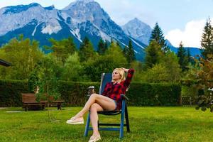 jong vrouw is staand door houten huizen. dorp in bergen. reis, levensstijl concept. Alpen, Europa. foto