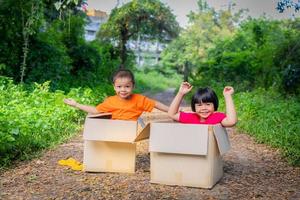 Aziatisch kinderen spelen in karton dozen foto