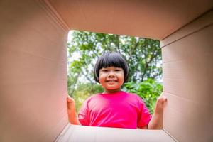 Aziatisch kinderen spelen in karton dozen foto