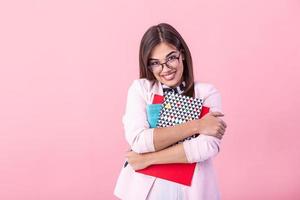 jong meisje tiener leerling Holding boeken geïsoleerd Aan roze achtergrond studio portret. onderwijs in hoog school- Universiteit college concept. foto