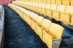 leeg geel stoelen Bij stadion, rijen loopbrug van stoel Aan een voetbal stadion foto