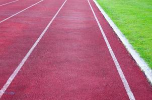 rennen bijhouden en groen gras, direkt atletiek rennen bijhouden Bij sport stadion foto