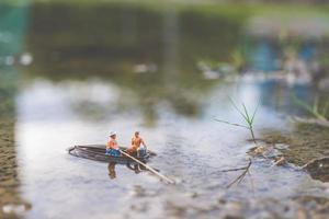 miniatuurvissers die op een boot vissen foto