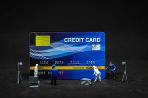 miniatuurpolitie en rechercheurs op een plaats delict op creditcards, cybercriminaliteitsconcept foto