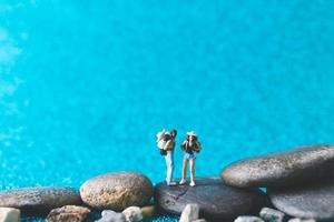 miniatuur backpackers, toeristenmensen op een blauwe glitterachtergrond