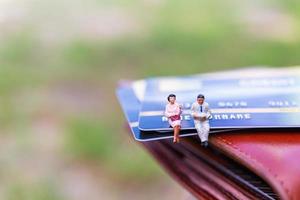 miniatuurondernemers zittend op een creditcard, zakelijke en financiële concepten foto