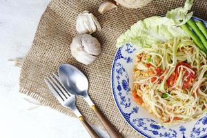 somtum, Thais pittig papaja salade Aan wit achtergrond, Internationale Thais voedsel bekend en populair, gemaakt met papaja en tomaten, het smaakt zuur, zoet en pittig. foto