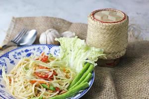 somtum, Thais pittig papaja salade Aan wit achtergrond, Internationale Thais voedsel bekend en populair, gemaakt met papaja en tomaten, het smaakt zuur, zoet en pittig. foto