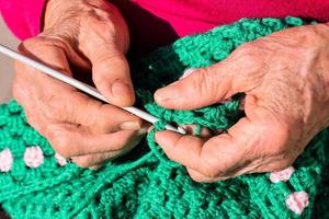 oud vrouw met breiwerk naalden en wol foto