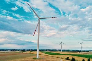 windmolen tussen agrarisch velden. wind turbine generator Bij zomer dag foto