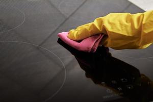 vrouw in rubber handschoenen schoonmaak inductie fornuis foto