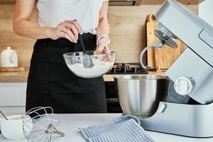 vrouw Koken Bij keuken en gebruik makend van keuken machine foto