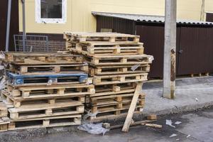 een stack van oud houten pallets in de werf , gebruikt pallets gestapeld Aan de trottoir foto
