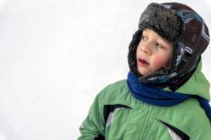 grappig Kaukasisch jongen van 5 jaren oud gekleed in warm winter sport- kleren foto