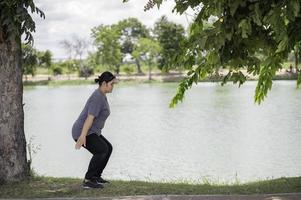 mooie Aziatische dikke vrouw speelt yoga in het park, moet een slank lichaam hebben foto
