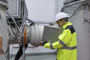 elektrisch ingenieur Mens controle Spanning Bij de macht distributie kabinet in de controle kamer, preventief onderhoud jaarlijks, thailand elektricien werken Bij bedrijf foto