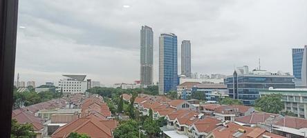 Jakarta, Indonesië. april 5, 2023. de achtergrond is woon- en meerdere verdiepingen gebouwen met wolken en blauw lucht foto