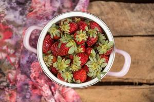 aardbeien in een kom op een houten tafel foto