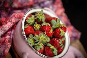 aardbeien in een kom op een houten tafel foto