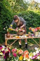 schattig bloemist meisje verzamelt een boeket van herfst bloemen in een mand foto