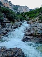 ontdekken de sereen schoonheid van een klein waterval genesteld Bij de voet van een berg een reis door de hart van natuur rustig pracht foto