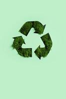 groen mos onder papier besnoeiing recycling symbool. opslaan planeet, ecologisch, recycling concept foto