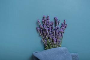 lavendel bloemen Aan gekleurde achtergrond met keuken handdoek top visie. kopiëren ruimte foto