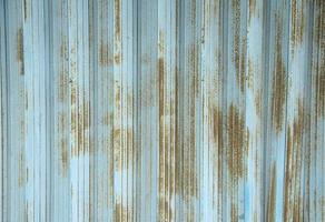 roestig oud en oud blauw staal ijzer glijden op te slaan deur met vlekken Aan het. muur achtergrond getextureerde afbeelding. foto