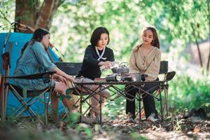 groep van jong Dames Koken terwijl camping in park foto