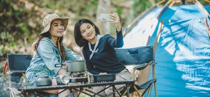 Aziatisch mooi vrouw en vriend gebruik smartphone selfie Aan camping foto