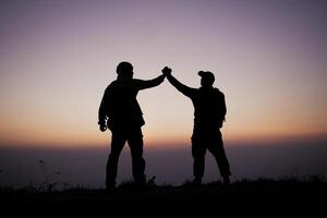 silhouet van samenspel helpen hand- vertrouwen helpen foto