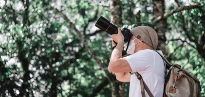 Aziatisch reiziger Mens met rugzak nemen een foto in de park